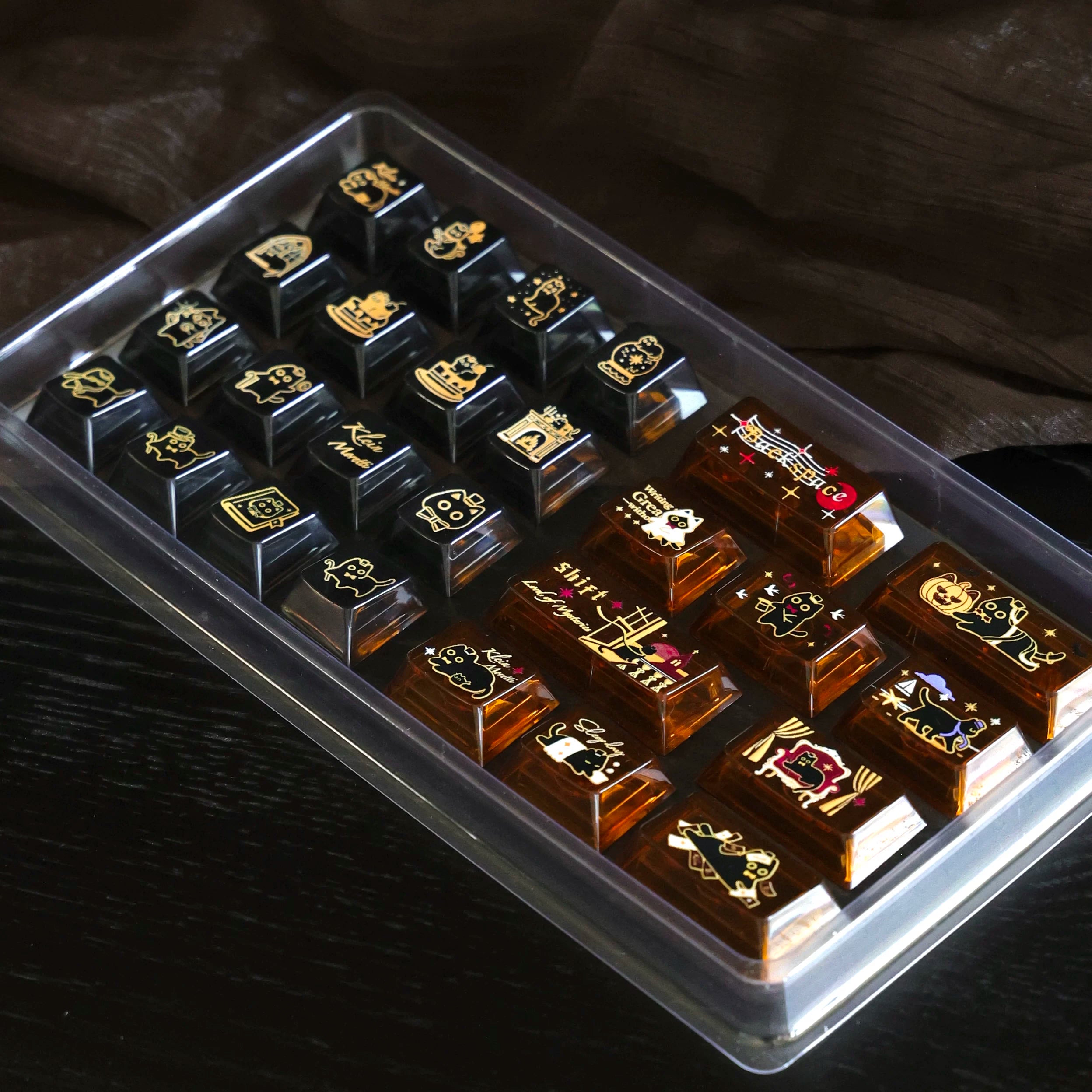 Angled view of dark and amber transparent cat keycaps