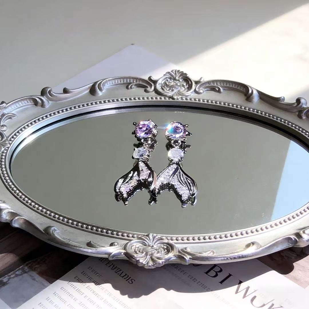 Love and Deepspace Rafayel inspired fishtail stud earrings on a velvet jewelry stand.